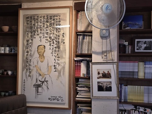 책장과 찻잔, 나무 테이블이 놓인 인사동 귀천 전통찻집 내부