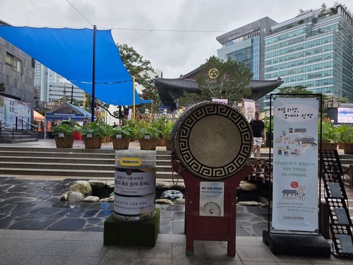 커다란 북과 연꽃 화분, 조계사 전각이 보이는 마당 풍경