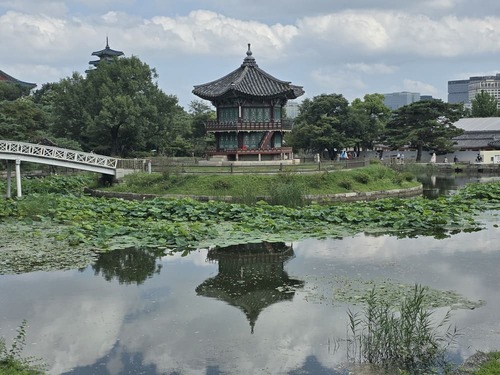 흐린 하늘 아래 향원정과 취향교가 향원지에 비친 전경